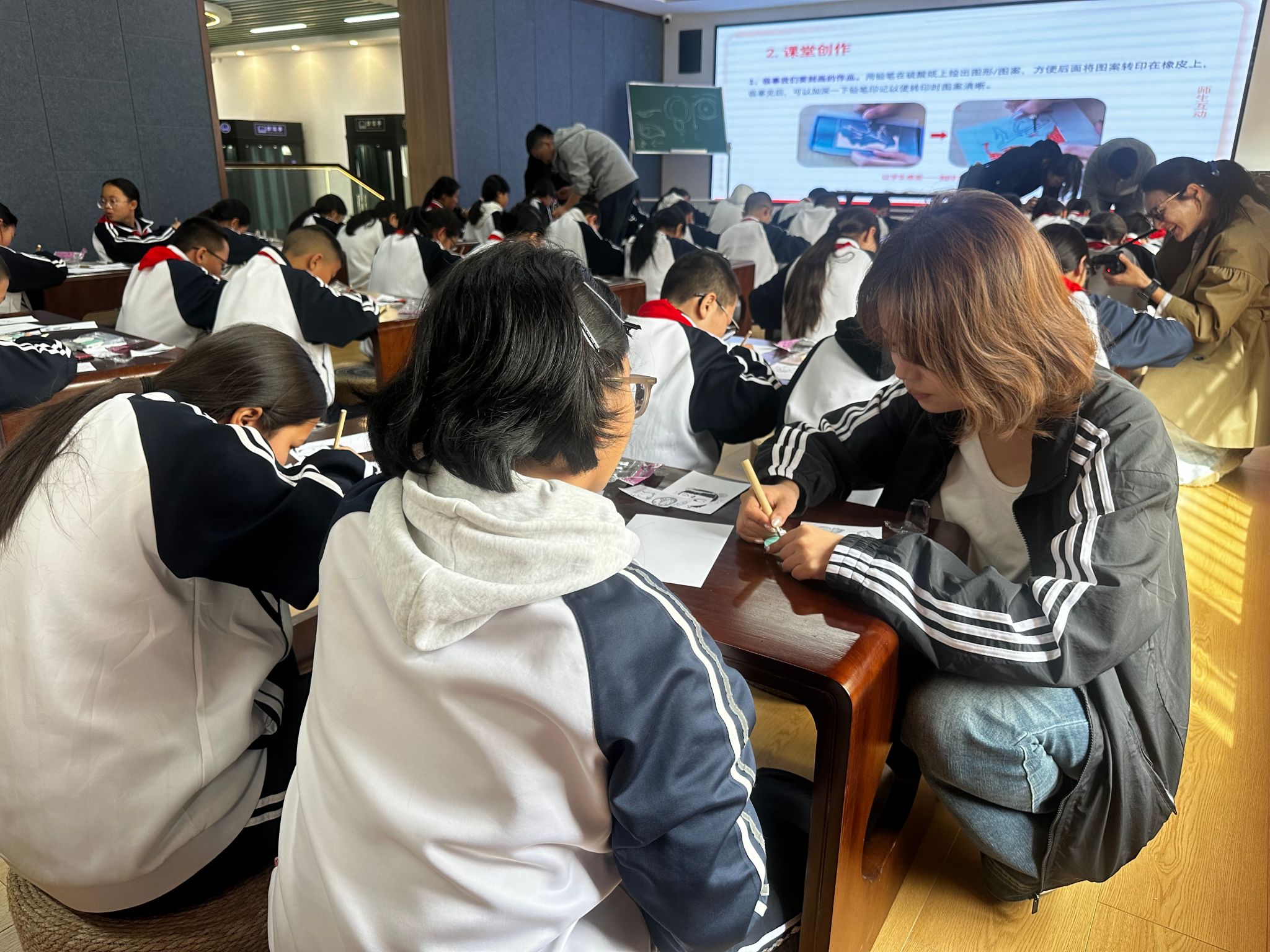 库车市第五小学实习生王灵惠为学生展示橡皮章工艺