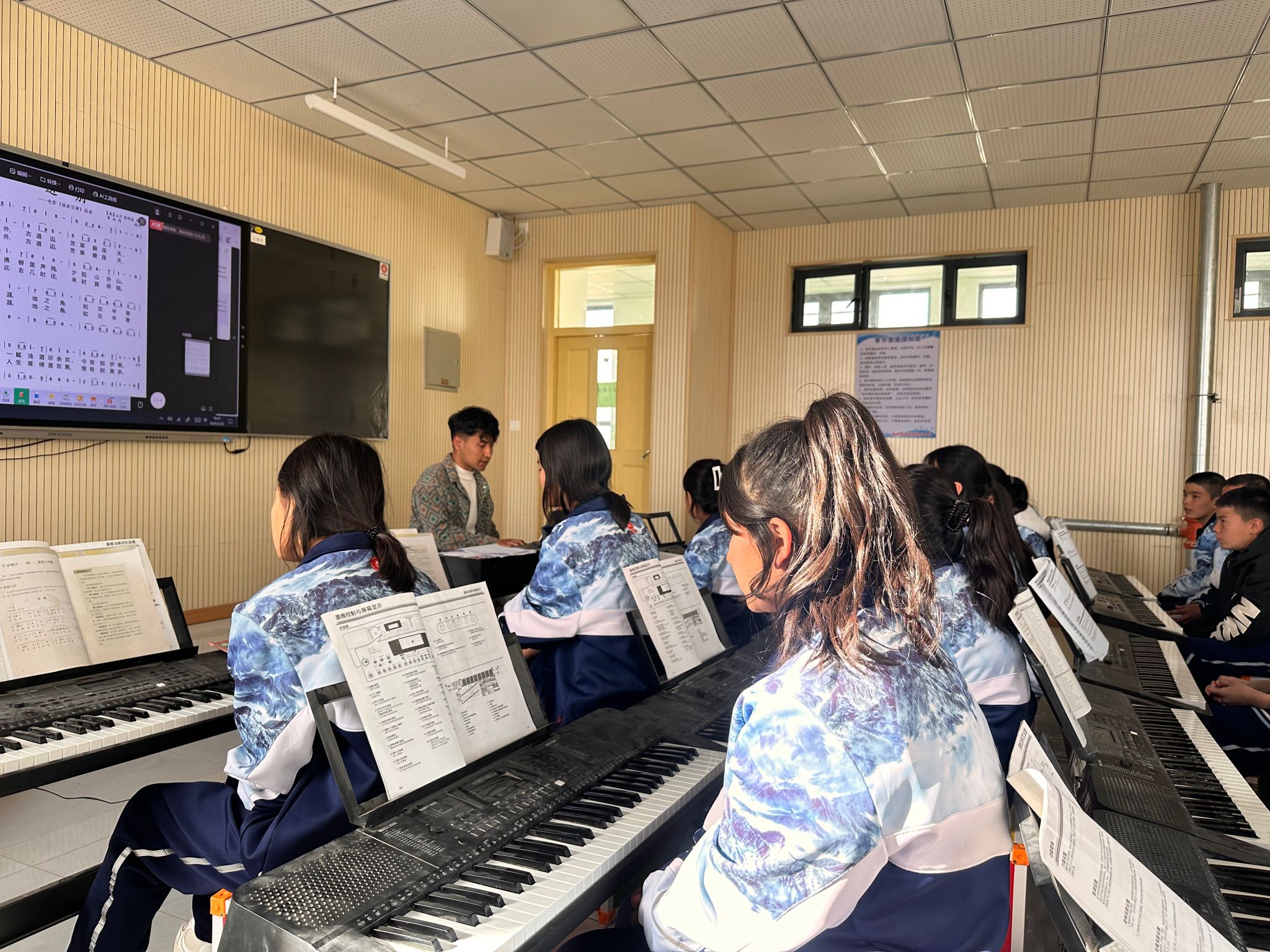 和田县巴格其中学实习生伊力亚尔·买买提居马组织排练《和田玫瑰》歌曲